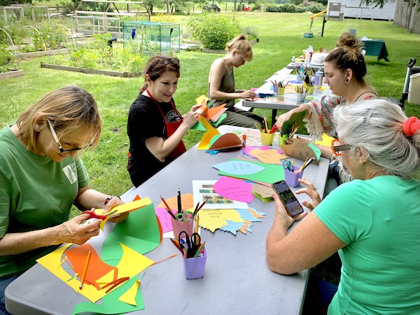 a group of artists working with colorful construction paper